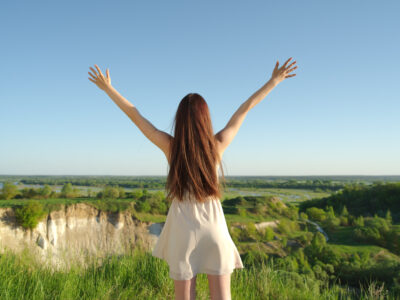 mujer-feliz-joven-relajada-brazos-levantados-al-aire-libre-naturaleza-nina-encuentra-brazos-levantados-cielo-chica-tranquila-pie-junto-acantilado-disfrutando-verano-al-aire-libre